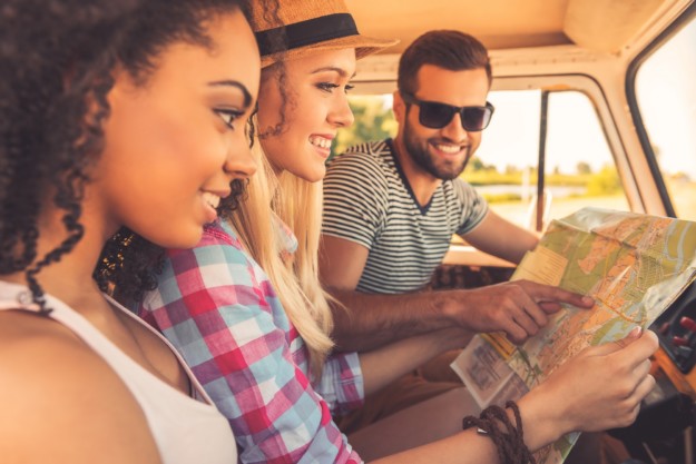 Group of young people looking at a map in a vehicle