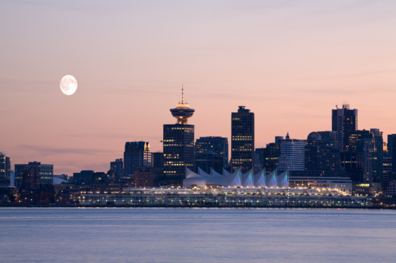 Moon in pink sky above Vancouver waterfront