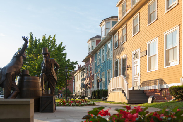 bronze statues next to colourful wooden buildings