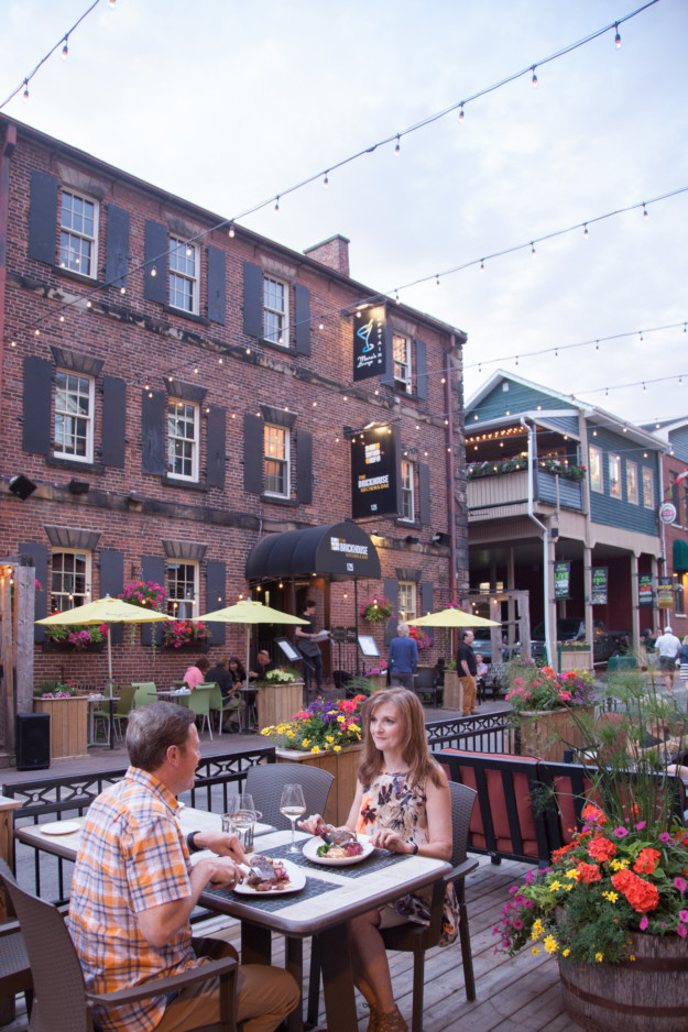 couple enjoy a meal together on the outdoor terrace of the Brickhouse Kitchen & Bar