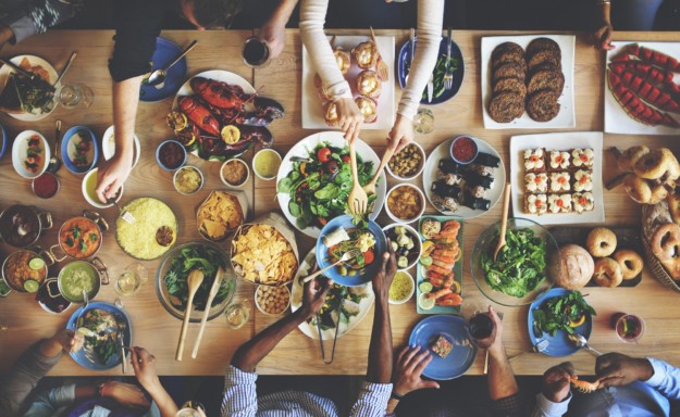 group shares a large spread of food at a table