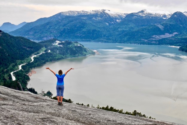 woman takes in the view across a lake in Western Canada