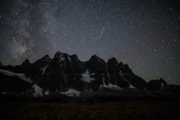 meteor shower over dark mountain