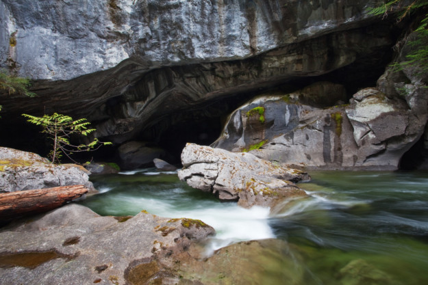 river rapids run through a cave system carved in the rocks