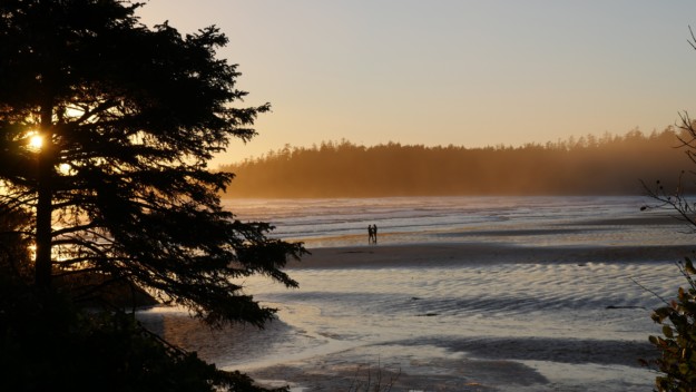two people enjoy the sunsetting on long beach, Tofino