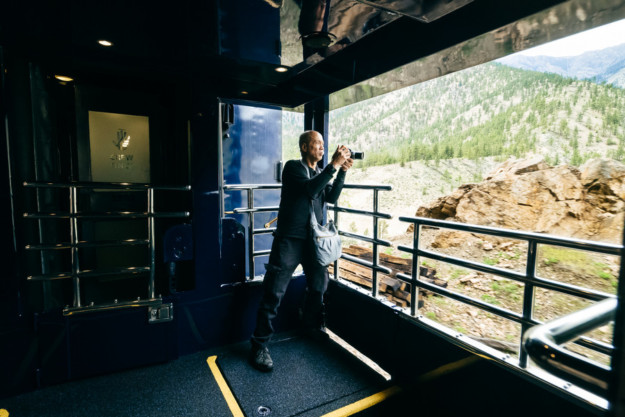 a man takes a photograph off the side of a train