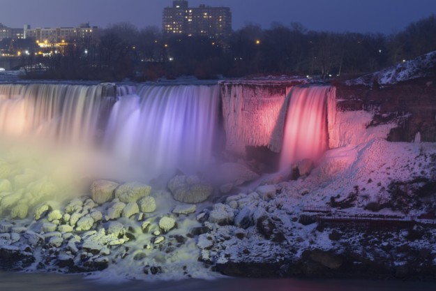 Niagara Falls frozen at night with colorful lights