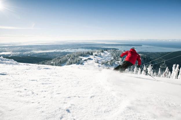 skier in red jacket descending the slopes