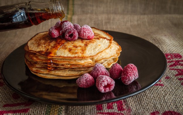 pancakes topped with raspberries and maple syrup