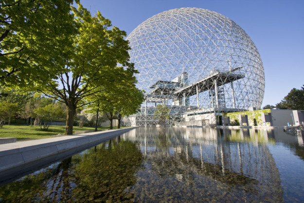 Montreal biosphere and leafy green trees reflected in pool