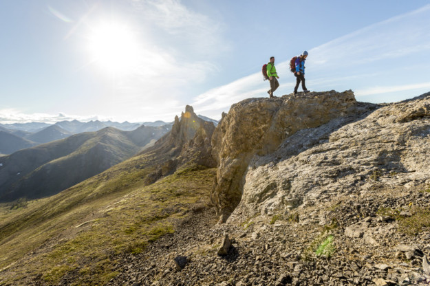 two hikers walk along a mountain ridge