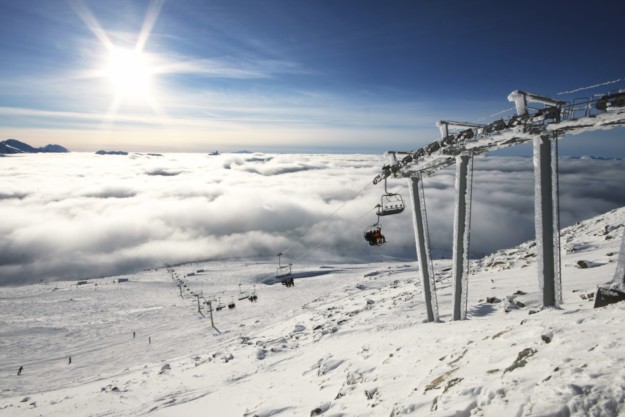 chair lift ascending above the clouds to a clear sky