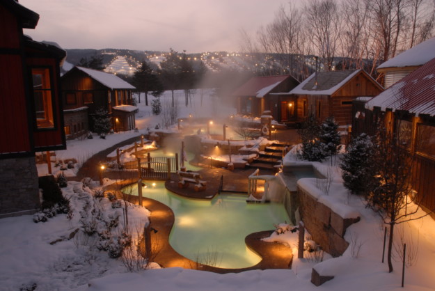 a heated pool surrounded by snow covered chalets