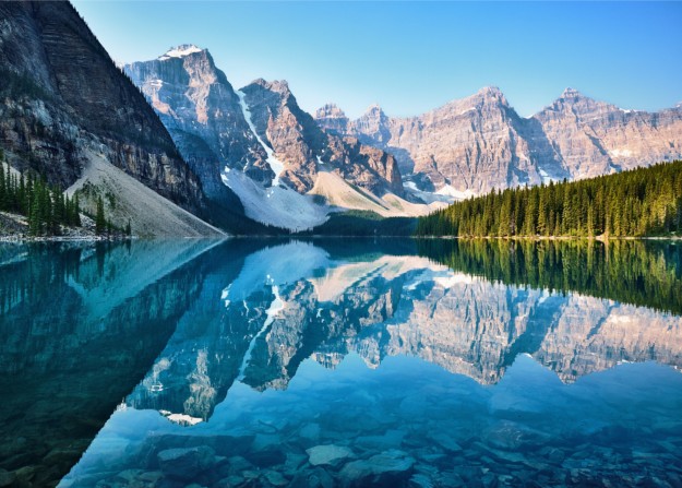 The mountains are reflected in the crystal clear water of Moraine Lake