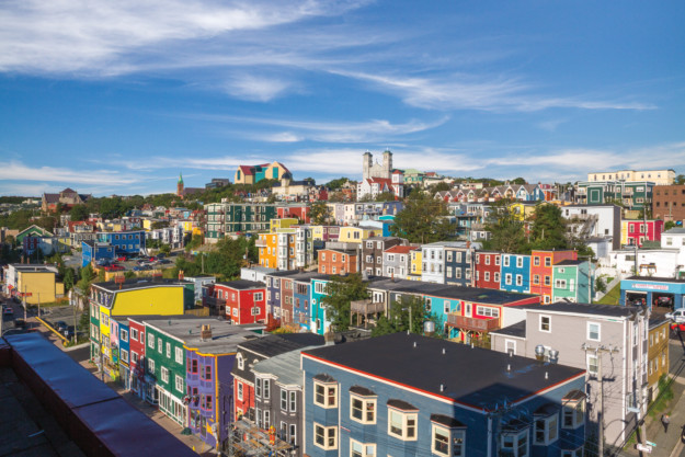 rows of multi-coloured houses sit on a hill in St. John's