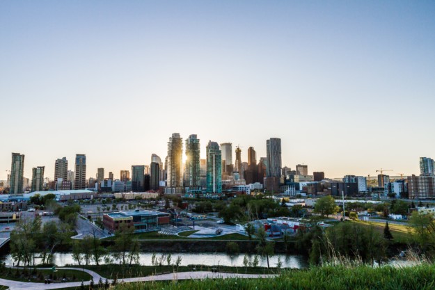 The sun sets behind the Calgary skyline