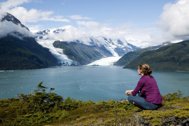 A woman admires a glacier and fjord in Alaska