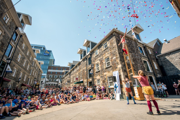 people gather round to watch street performers