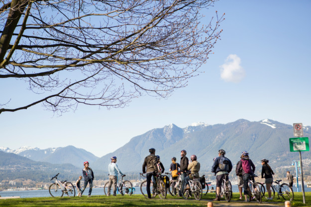 a big group of cyclists take a break in Stanley Park, Vancouver