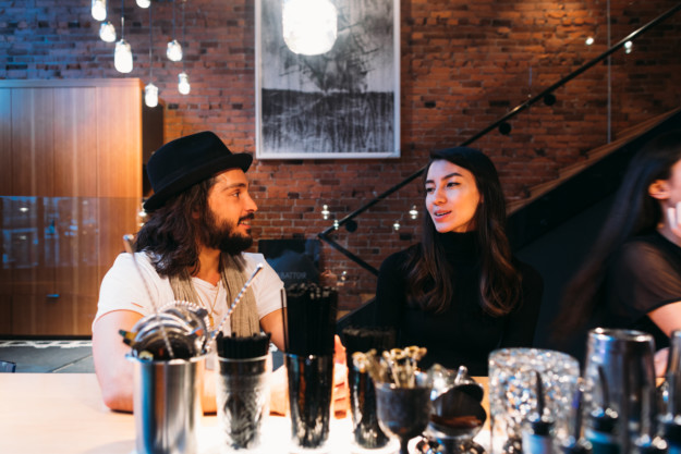 a trendy couple sit at a bar