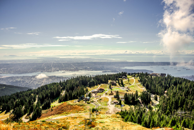 a view down a yellow and green hilltop towards Vancouver