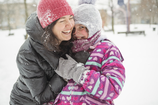 Two women dressed in winter clothes hug