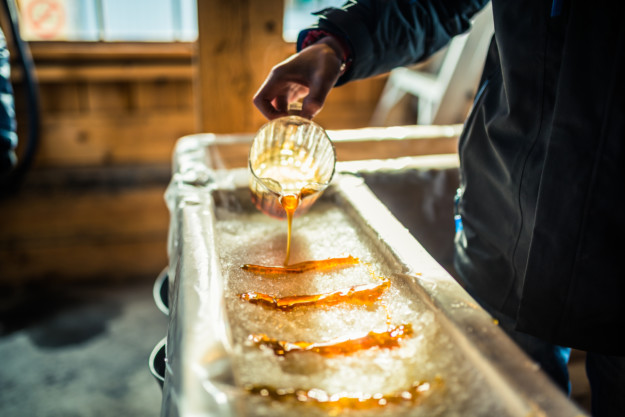 Maple syrup being poured into a long, narrow tray