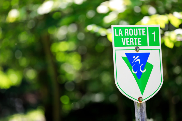 A green and white road sign reading 