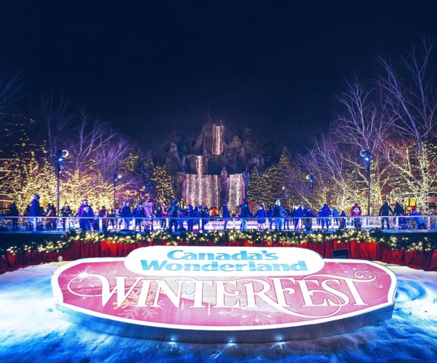 Ice skating rink full of people with Winterfest sign in the foreground