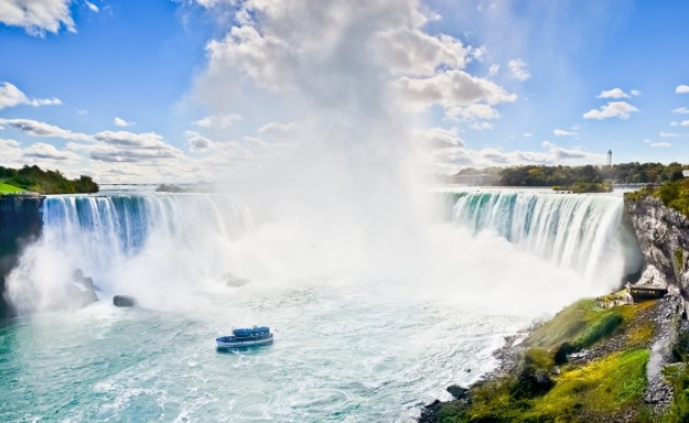 the mist sprays up from Niagara Falls near a tour boat