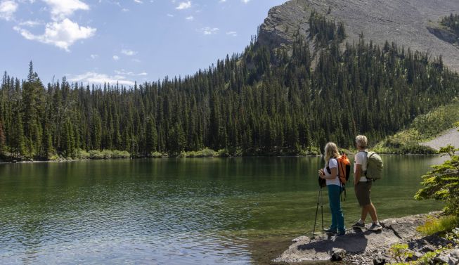 a hiking couple look across a lake