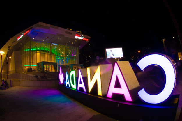 A night image with a Canada sign in the foreground