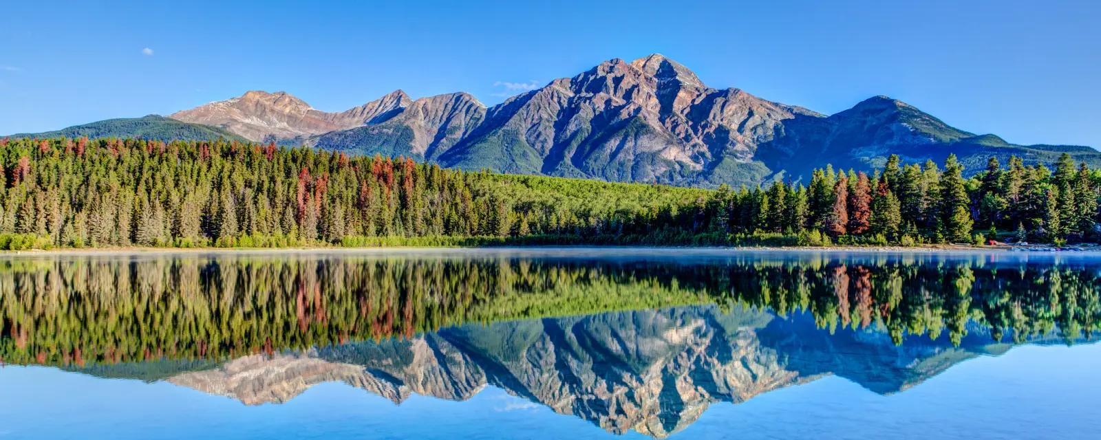 a mountain is reflected in a crystal clear lake