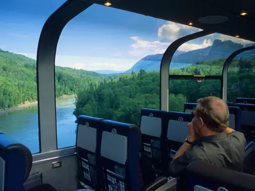 A passenger enjoys the scenic view of the Skeena River  from the comfort of the VIA Rail observation car.
