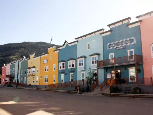 The Unique Yukon town of Dawson City,  with colorful two-story buildings in different shades of pink, light blue, green, and yellow.