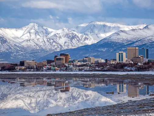 Anchorage skyline with modern buildings set against a backdrop of snow-capped mountains