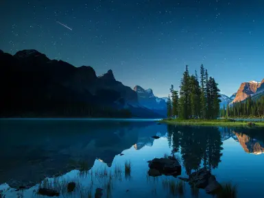 Maligne Lake at dusk reflecting a starry sky
